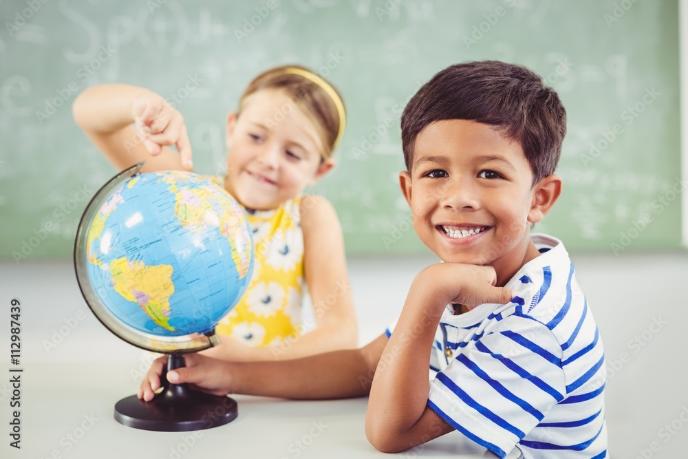 Fototapeta premium Happy school kids with globe in classroom