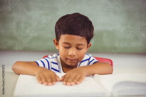 Tableau sur toile School boy memorizing the lesson in classroom