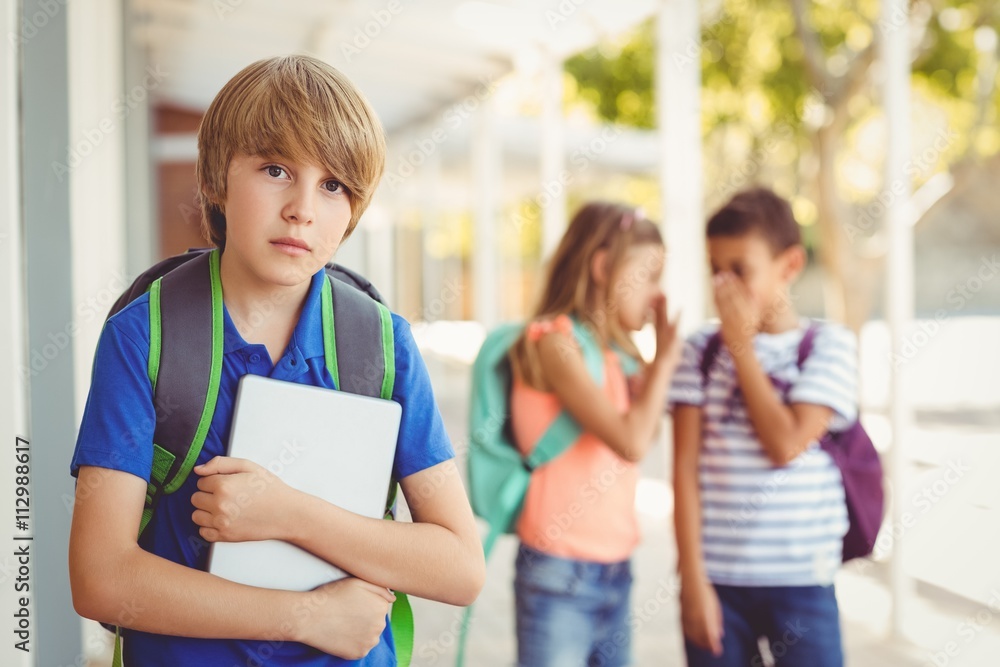 School friends bullying a sad boy in corridor School friends bullying a sad boy in corridor