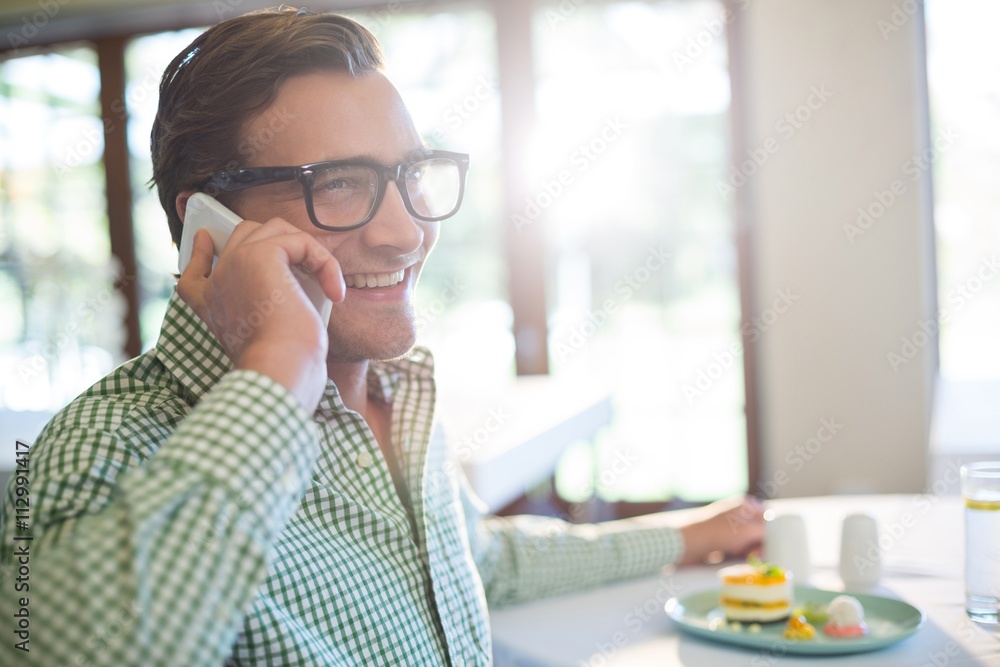 Happy man talking on mobile phone while having a lunch Happy man talking on mobile phone while having a lunch