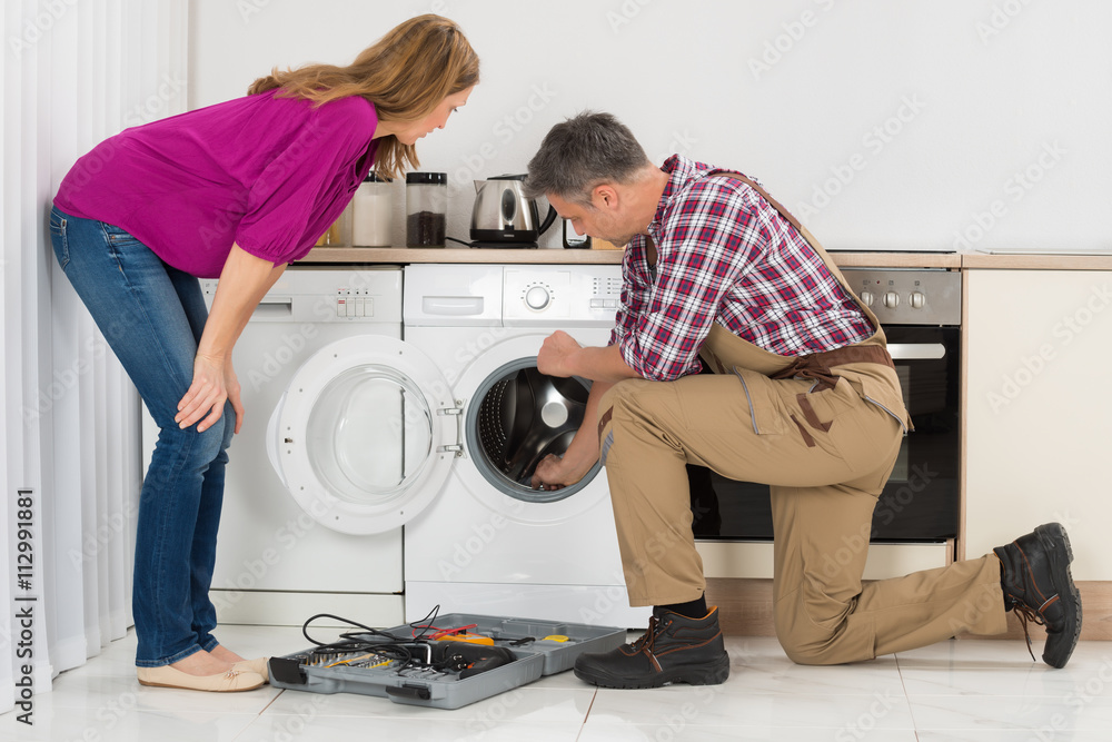 Repairman Checking Washing Machine Repairman Checking Washing Machine