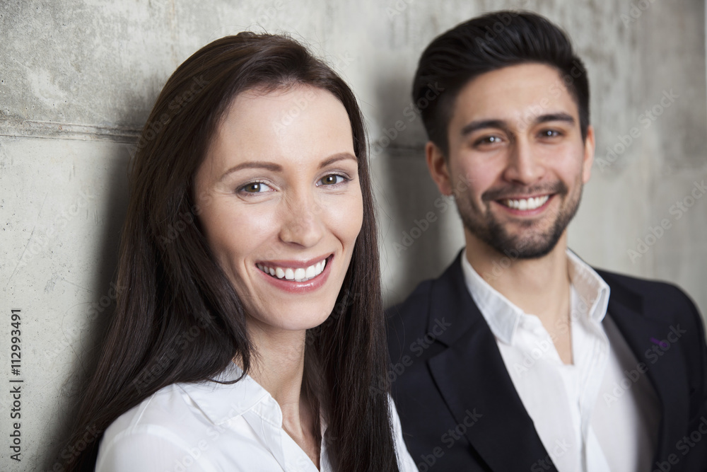 Portrait of a businesswoman and businessman, head and shoulders, focus on woman Portrait of a businesswoman and businessman, head and shoulders, focus on woman