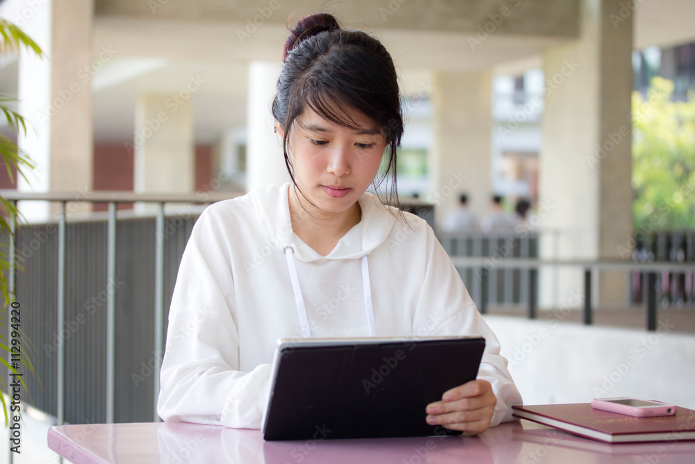 Portrait of thai student university beautiful girl using her tablet Portrait of thai student university beautiful girl using her tablet