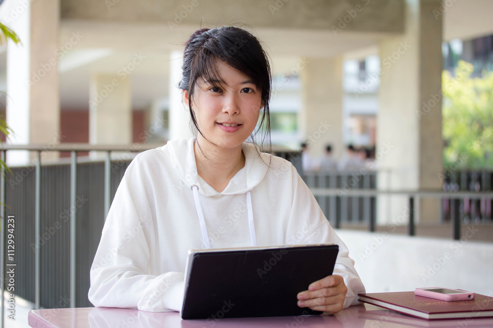 Portrait of thai student university beautiful girl using her tablet Portrait of thai student university beautiful girl using her tablet