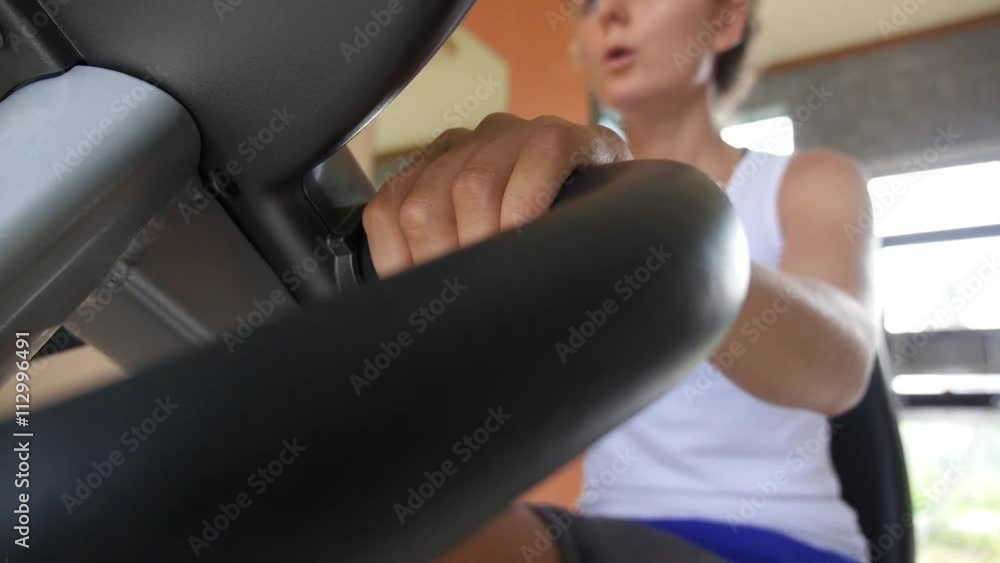 Woman Riding on Bicycle in Gym Performing Cardio Exercises Woman Riding on Bicycle in Gym Performing Cardio Exercises