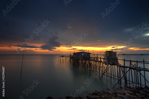 Long exposure image of  langgai  during beautiful sunset   the traditional fishing medium at Malaysia .Image has certain noise and soft focus when view at full resolution