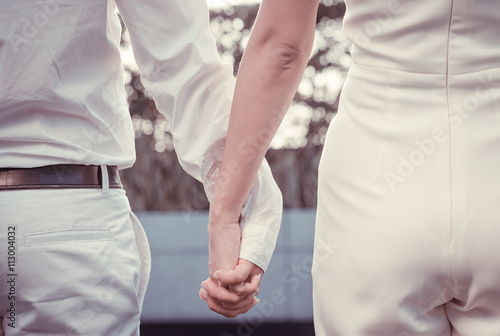 Close up of cute young newlyweds holding their hands