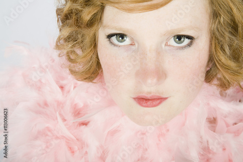 Portrait of a young woman wearing a pink feather boa photo