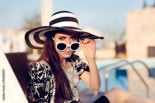 Surprised  Girl With Sunglasses and Hat  Sitting on Sun Chair