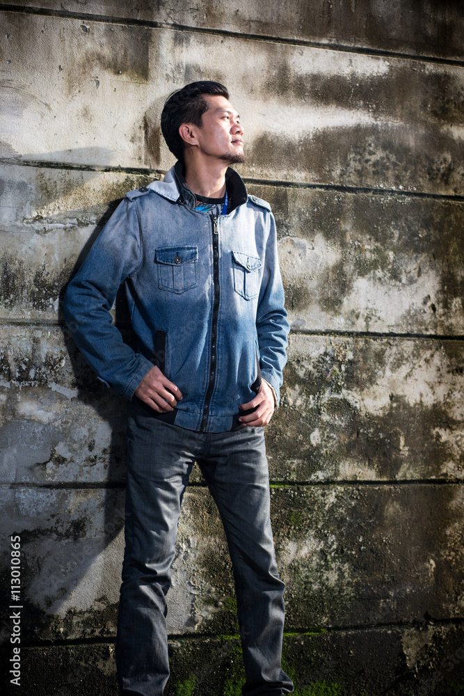 Obraz premium Asian young man wearing jeans clothes stand on the ground in fro