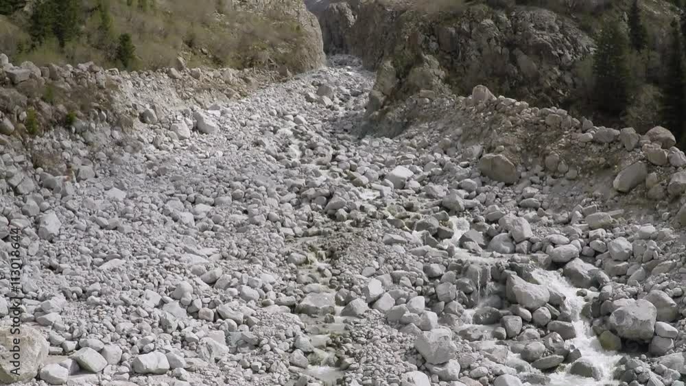 Aerial camera rises above mountain stream on white rocks Aerial camera rises above mountain stream on white rocks