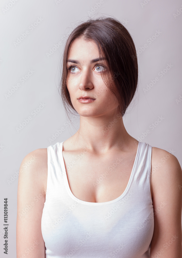 Woman in T shirt on grey background in studio Woman in T shirt on grey background in studio