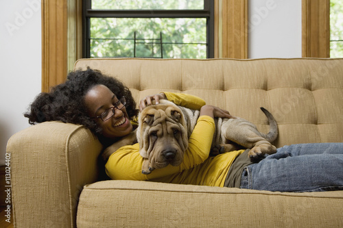 A woman lying a couch with her Shar-Pei photo