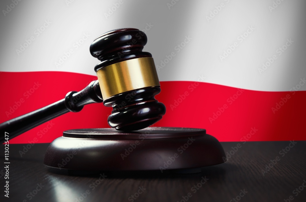 Wooden gavel with Polish flag in background