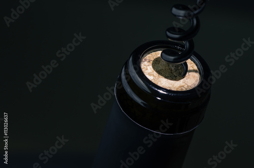 Black corkscrew opens wine