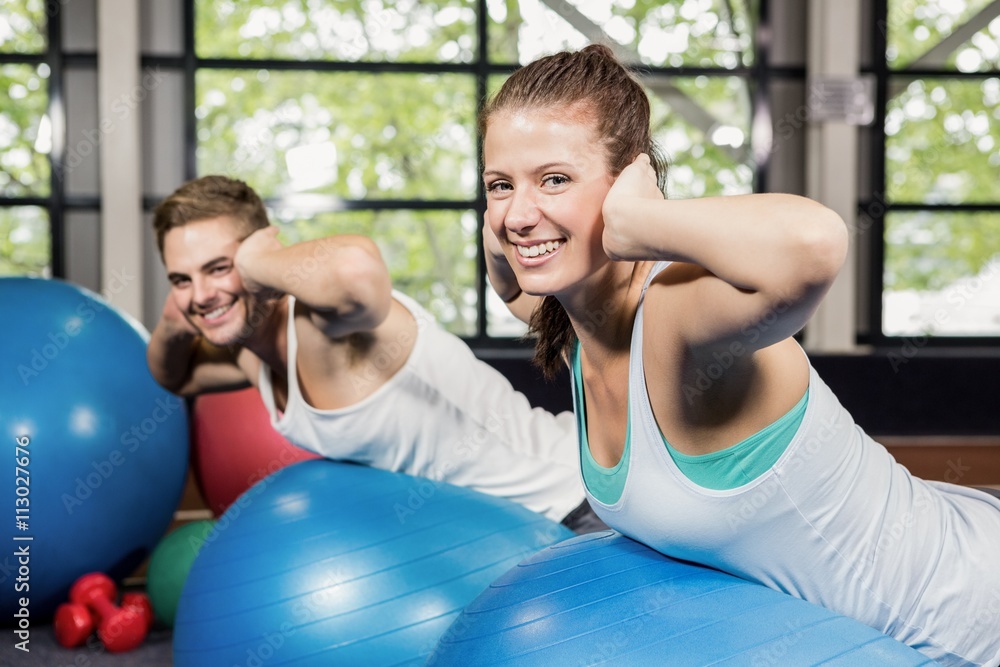 Man and woman working out on fitness ball Man and woman working out on fitness ball