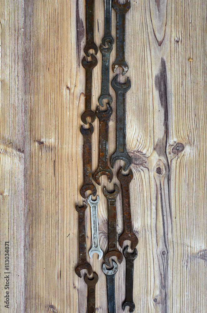Set of old spanners. Rough spanners on wooden background. Frame of metallic tools Set of old spanners. Rough spanners on wooden background. Frame of metallic tools