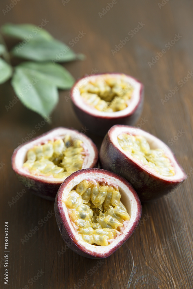 Passion fruit with green leaves on wooden desk Passion fruit with green leaves on wooden desk