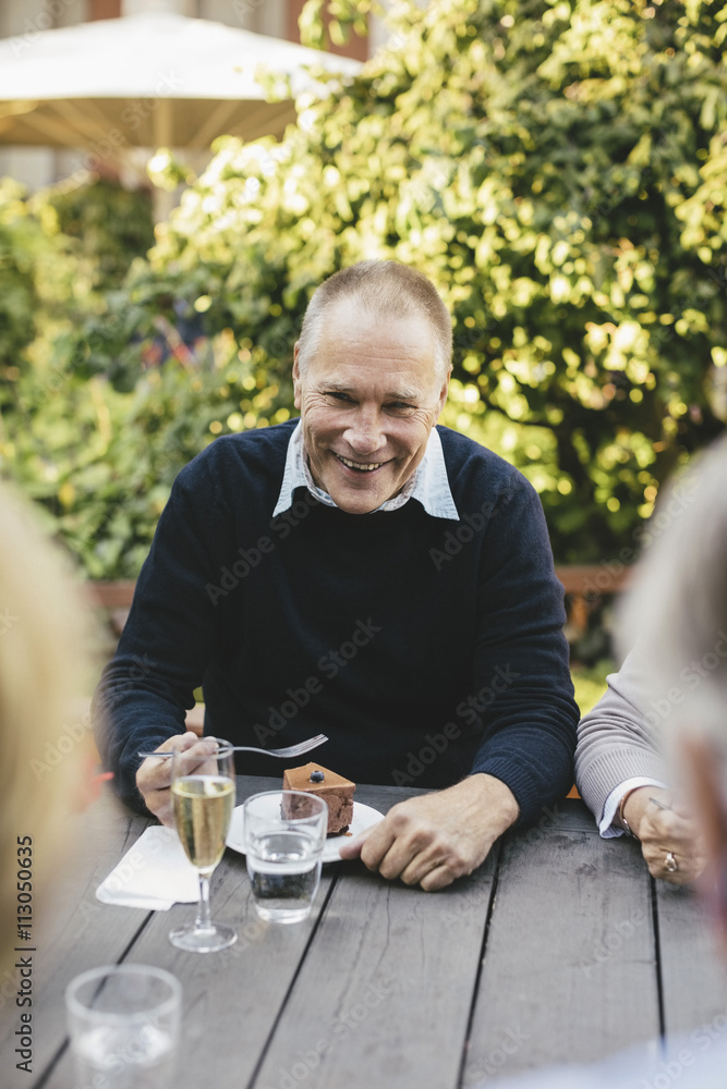 Portrait of happy senior man having dessert with friends at cafe table Portrait of happy senior man having dessert with friends at cafe table