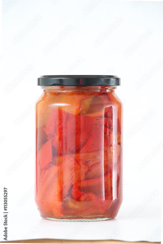 Isolated glass jar with conserved roasted red paprika Isolated glass jar with conserved roasted red paprika