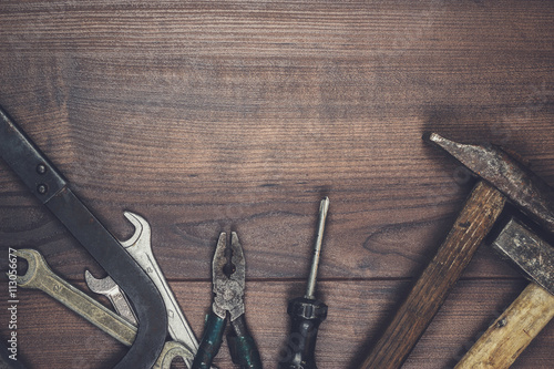 rusty construction tools on the wooden background photo