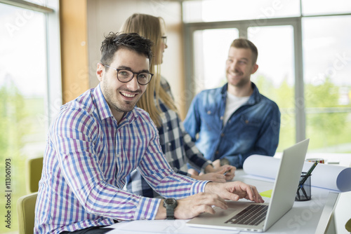 Photo of young freelance designers working in office