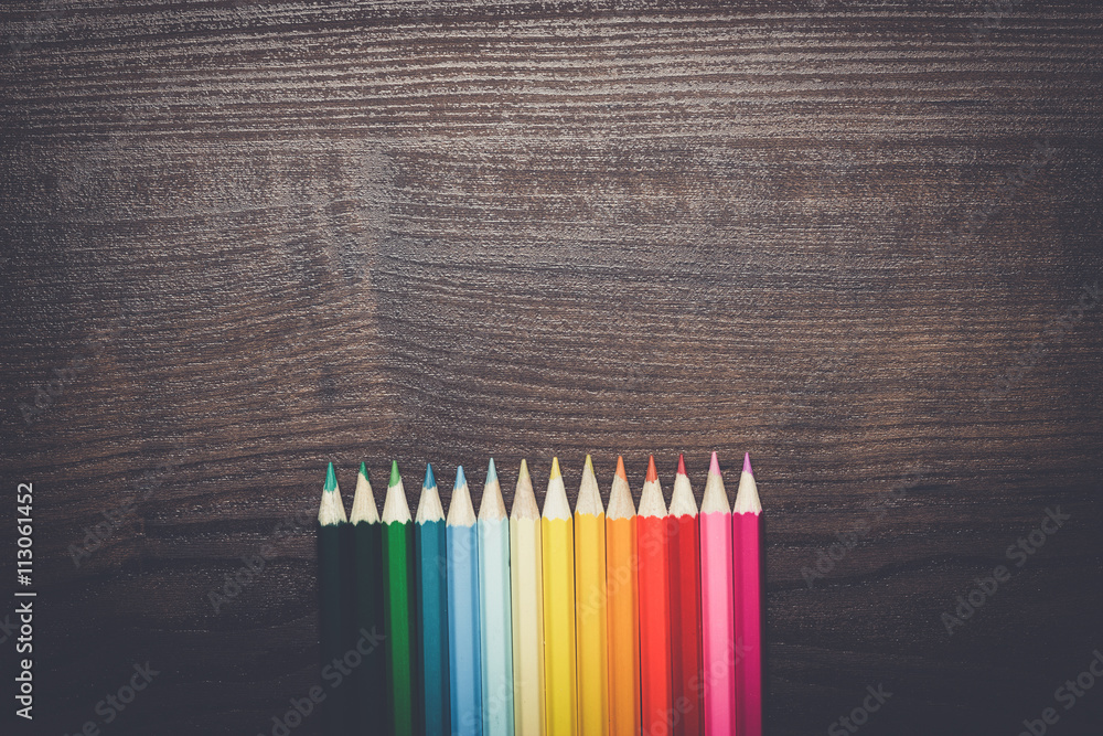 colorful pencils on the brown wooden table background colorful pencils on the brown wooden table background