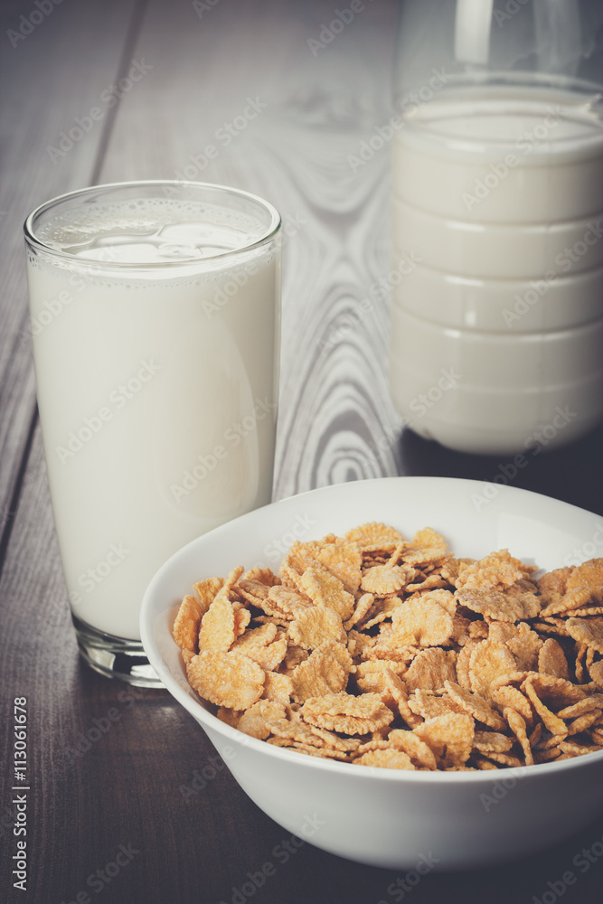 glass of milk and bowl of cornflakes on the table glass of milk and bowl of cornflakes on the table