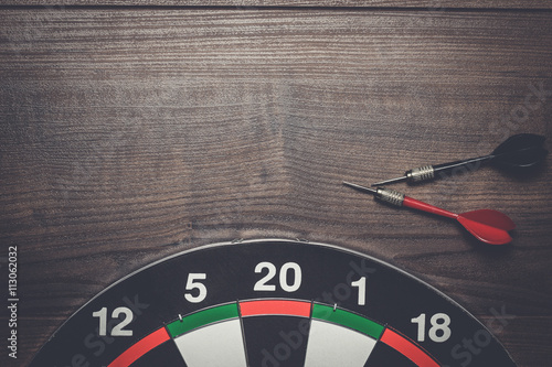 target and two darts on the brown wooden table photo