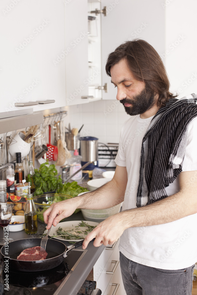 Man preparing meat in domestic kitchen Man preparing meat in domestic kitchen