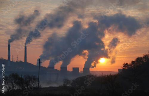 Factory pipe polluting air, environmental problems, smoke from chimneysagainst sunset