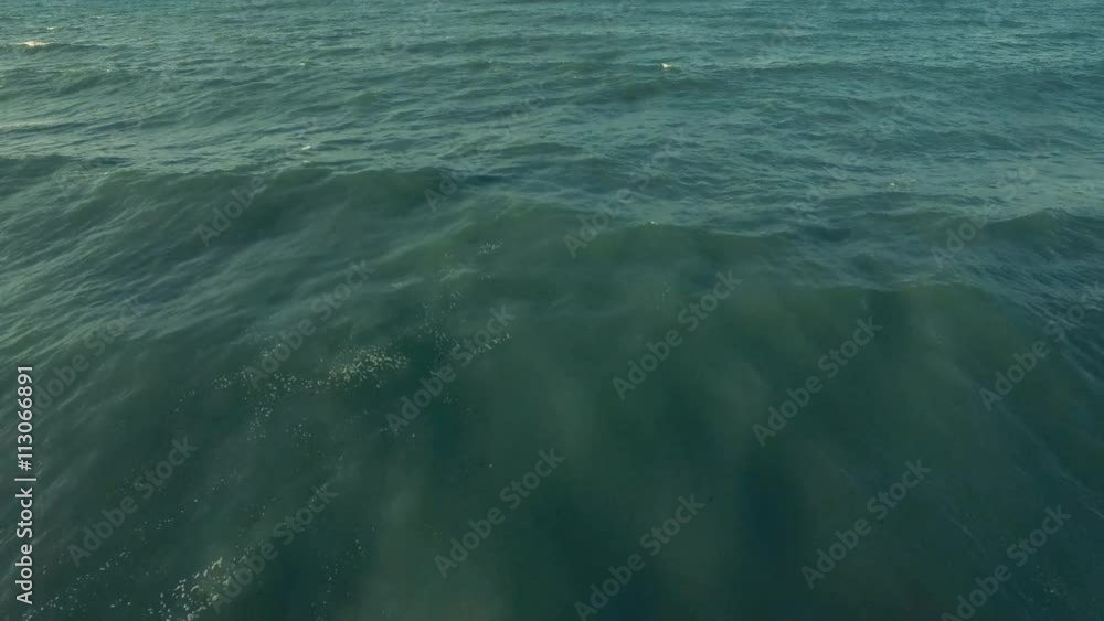 Aerial shot of a beautiful sunrise sparkling off the sea and sand Aerial shot of a beautiful sunrise sparkling off the sea and sand