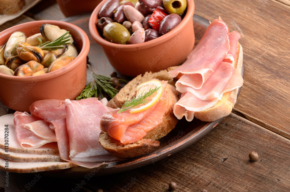 Tapas of salmon, mussels, jamon and olives Tapas of salmon, mussels, jamon and olives