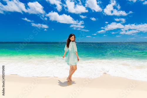 Young beautiful Asian  girl in blue dress on the beach of a trop