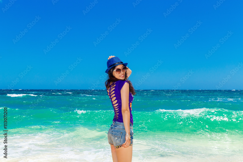 Young beautiful Asian girl on a tropical beach. Summer vacation