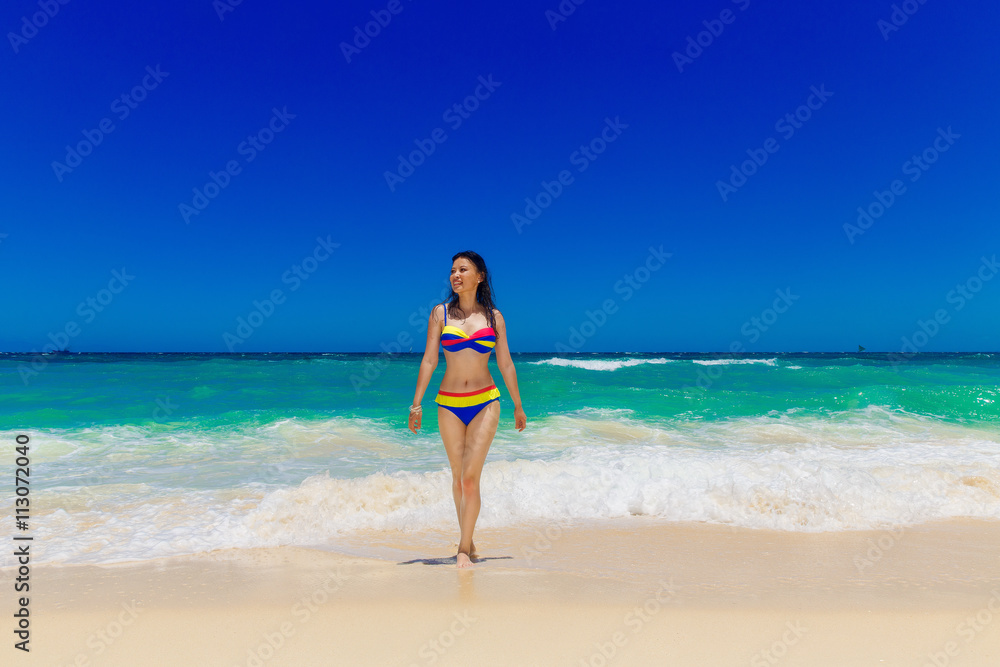 Young beautiful Asian girl with long black hair in bikini, on t Young beautiful Asian girl with long black hair in bikini, on t