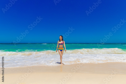 Young beautiful Asian girl in bikini, on the tropical beach