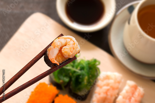 Sushi set with chop sticks, wasabi served on wooden slate, selec photo