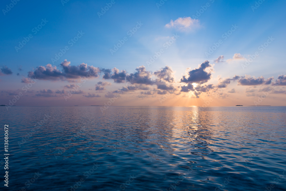 Magnificent panorama of sunset over the ocean. Rays of the sun shine through the clouds. Magnificent panorama of sunset over the ocean. Rays of the sun shine through the clouds.