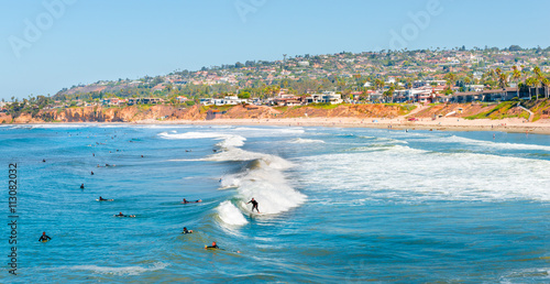 Summer fun. Coast San Diego, California. Surfers in the ocean waiting for a wave. photo