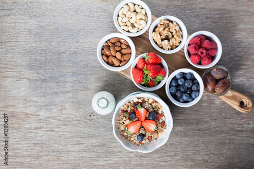 Paleo style breakfast: grain free oat free granola with almond milk and with mixed nuts, and fresh berries, top view, selective focus