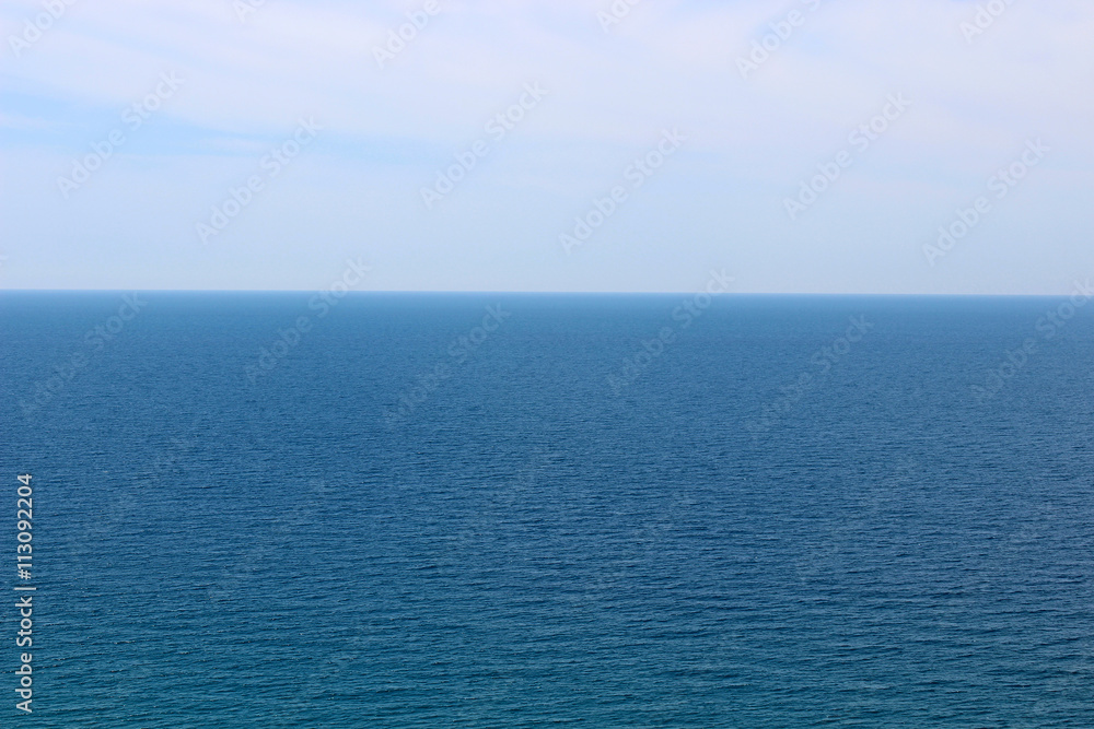 Blue sea waters and clear blue sky horizon