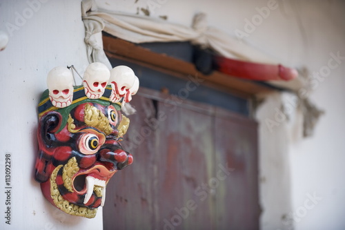 Mask and phallus hanging on a door to protect its occupants, near the temple of the Divine Madman, Metshina, Punakha, Bhutan