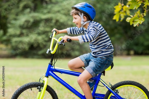 Fototapeta Naklejka Na Ścianę i Meble -  Smiling boy riding a bicycle