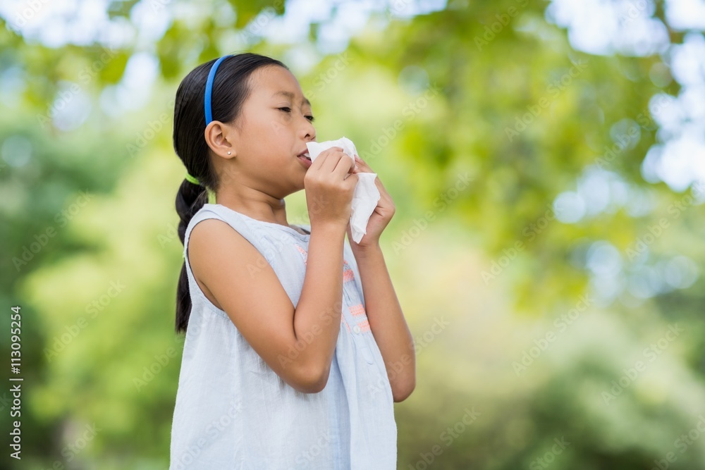 Girl blowing her nose with handkerchief while sneezing Girl blowing her nose with handkerchief while sneezing