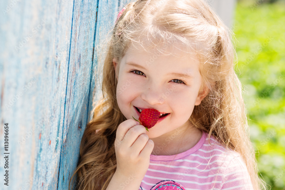 Happy small child eating strawberries Happy small child eating strawberries