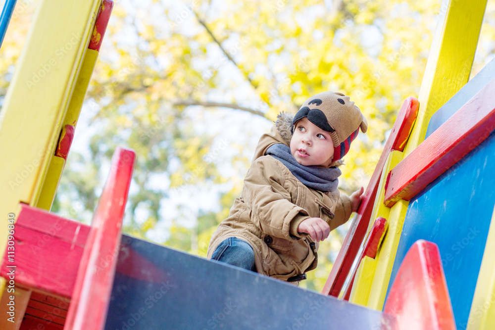 Curious Toddler boy climbing on playground Curious Toddler boy climbing on playground