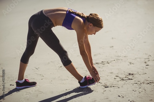 Fit woman warming up on beach