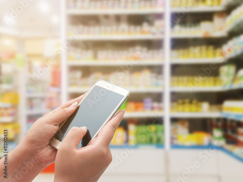 Women using smart phone on pharmacy