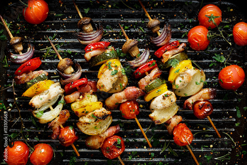 Fotografiet Grilled vegetable and meat skewers in a herb marinade on a grill pan, top view